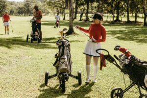 a woman in a golf outfit with a golf push cart